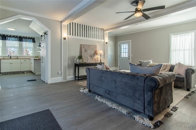 living room featuring ceiling fan, ornamental molding, sink, and light hardwood / wood-style flooring