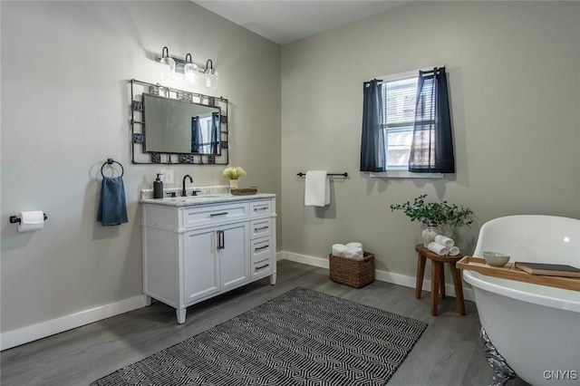 bathroom featuring wood-type flooring, vanity, and a bathtub