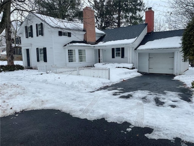 snow covered house featuring a garage