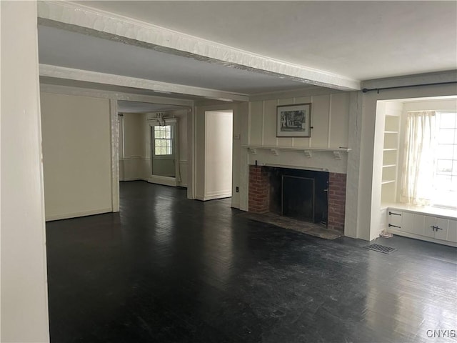 unfurnished living room featuring a brick fireplace and dark hardwood / wood-style flooring