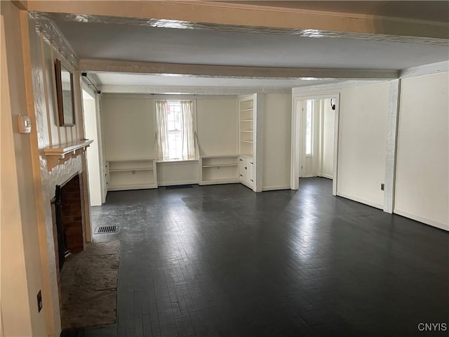 unfurnished living room with beam ceiling