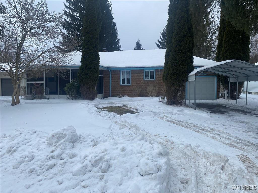 view of front of property with a carport, a sunroom, and a garage