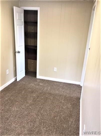 unfurnished bedroom with dark colored carpet