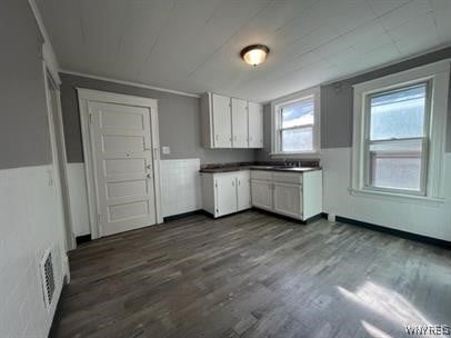 kitchen with dark wood-type flooring and white cabinets