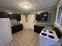 kitchen featuring white appliances, ornamental molding, and dark brown cabinetry