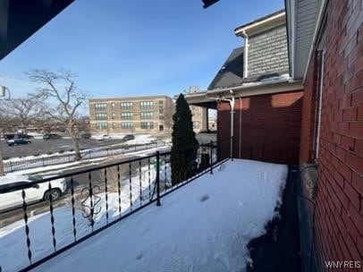 view of snow covered back of property