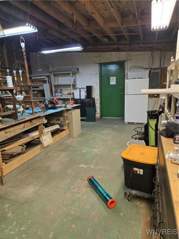 basement featuring a workshop area and white fridge