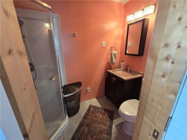 bathroom featuring vanity, tile patterned flooring, toilet, and walk in shower