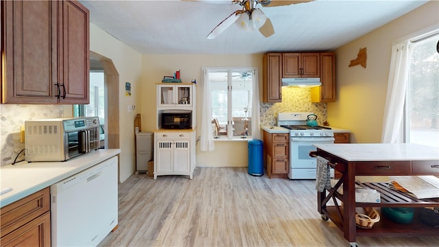 kitchen featuring tasteful backsplash, white appliances, plenty of natural light, and light hardwood / wood-style floors