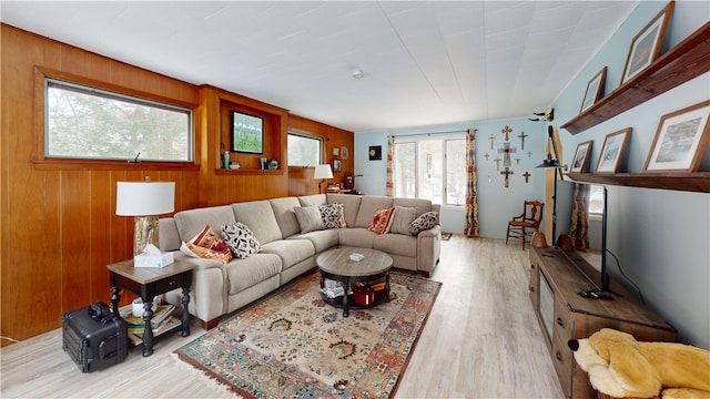 living room featuring wooden walls and light hardwood / wood-style floors