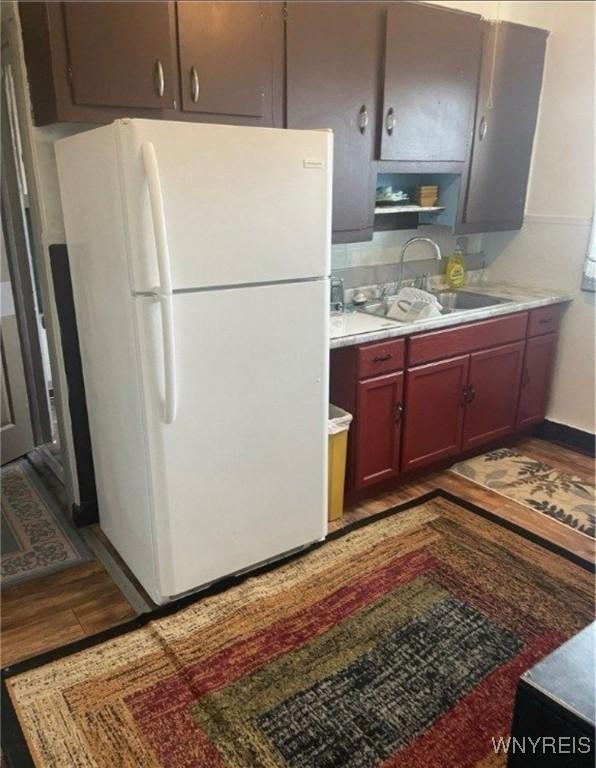 kitchen with white refrigerator, sink, and light wood-type flooring