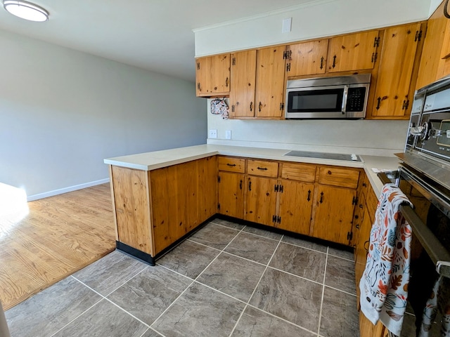 kitchen with black electric stovetop and kitchen peninsula