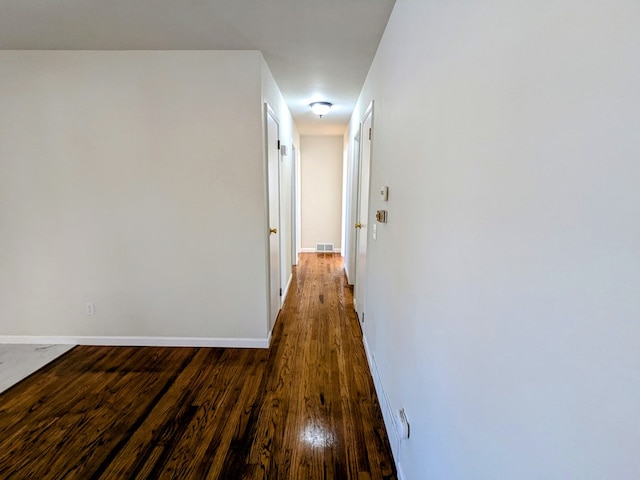 hallway with dark hardwood / wood-style flooring