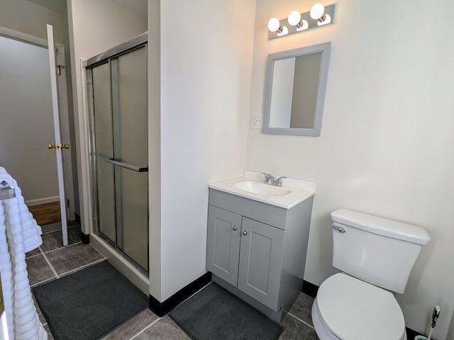 bathroom with toilet, vanity, and a shower with shower door