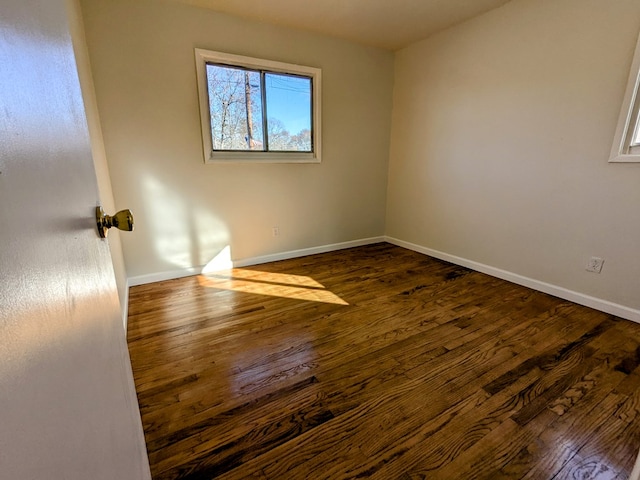 unfurnished room with dark hardwood / wood-style flooring