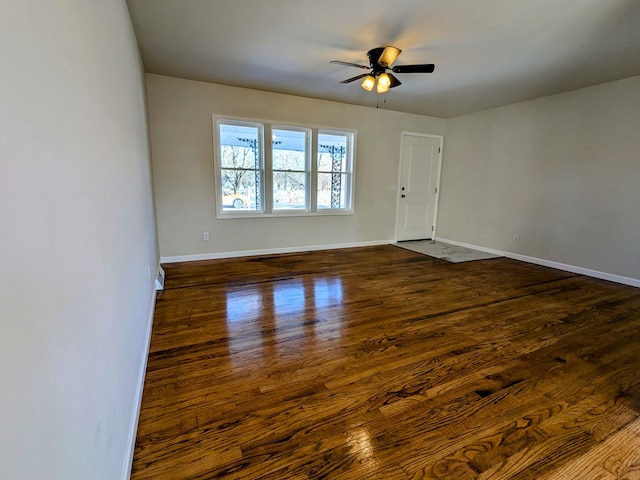 empty room featuring dark wood-type flooring and ceiling fan