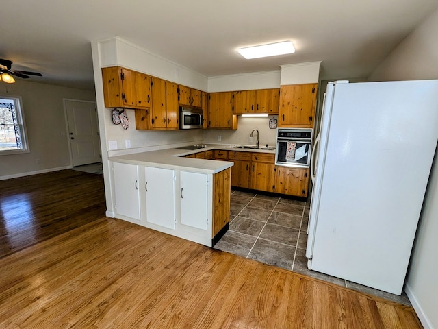 kitchen with dark hardwood / wood-style flooring, kitchen peninsula, sink, and black appliances