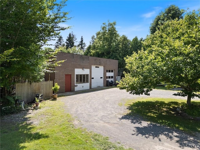 view of front facade featuring a garage, an outdoor structure, and a front yard