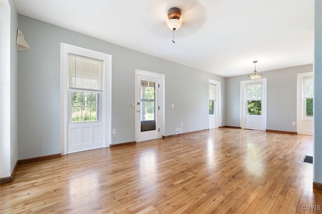 unfurnished living room featuring a wealth of natural light and light hardwood / wood-style flooring