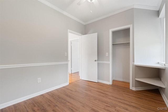 unfurnished bedroom with crown molding, ceiling fan, wood-type flooring, and a closet