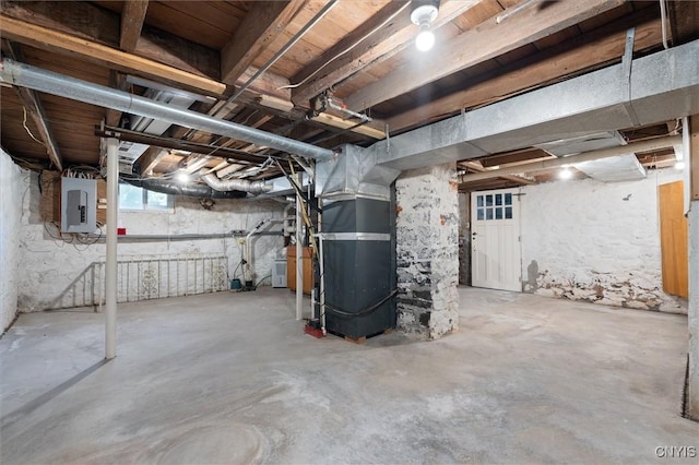 basement featuring heating unit and electric panel