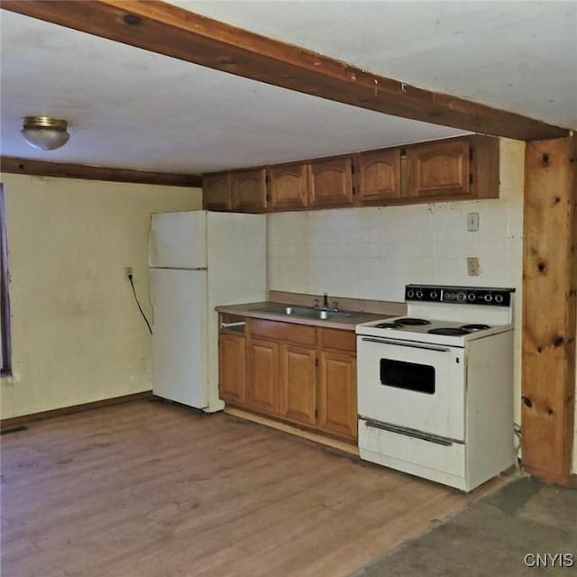 kitchen featuring beam ceiling, sink, white appliances, and light hardwood / wood-style floors