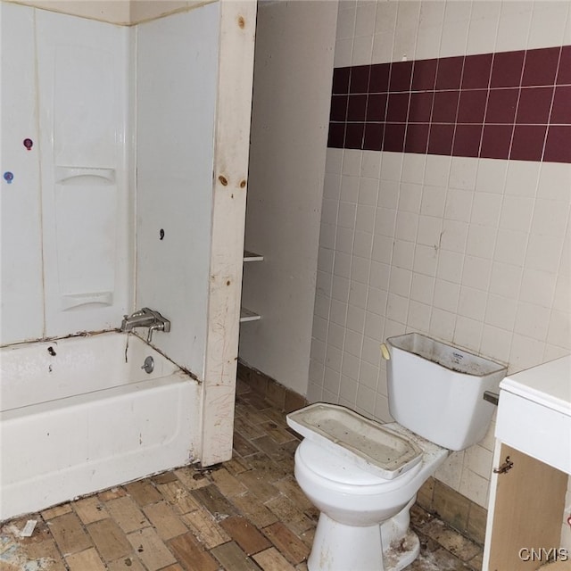 full bathroom with vanity, toilet, bathing tub / shower combination, and tile walls