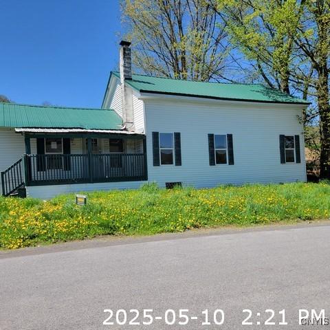 207 S Rd, Plainfield, NY 13491 - view of side of home featuring a chimney, metal roof, and a porch