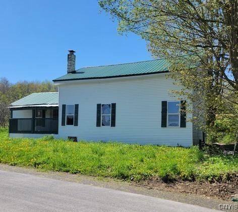 207 S Rd, Plainfield, NY 13491 - view of side of home with a chimney and metal roof