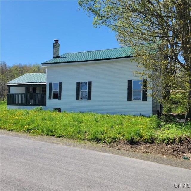 207 S Rd, Plainfield, NY 13491 - view of property exterior with a chimney and metal roof