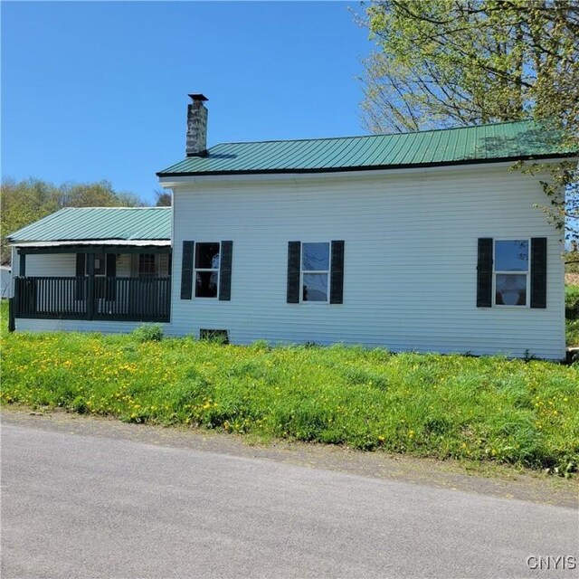 207 S Rd, Plainfield, NY 13491 - view of home's exterior featuring a chimney and metal roof