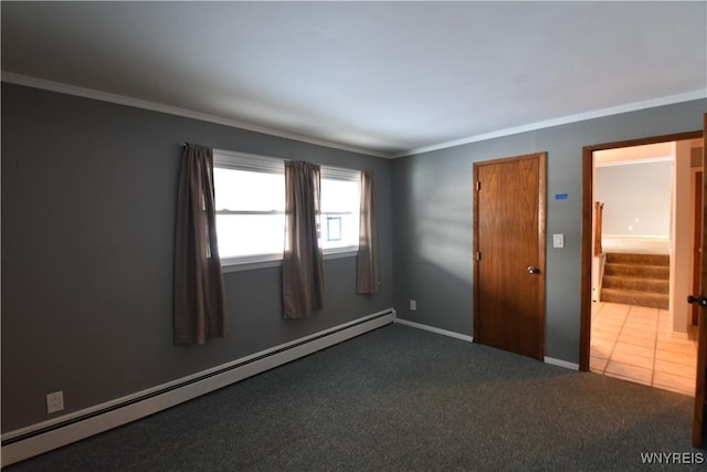 carpeted spare room featuring ornamental molding and a baseboard heating unit