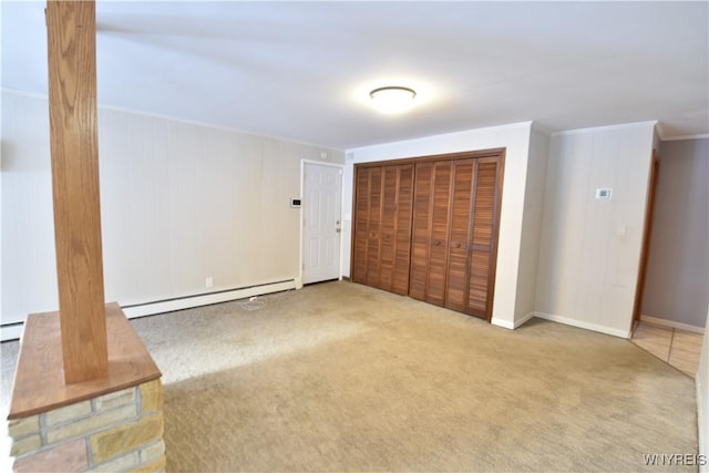 interior space featuring ornamental molding, a baseboard radiator, light colored carpet, and a closet