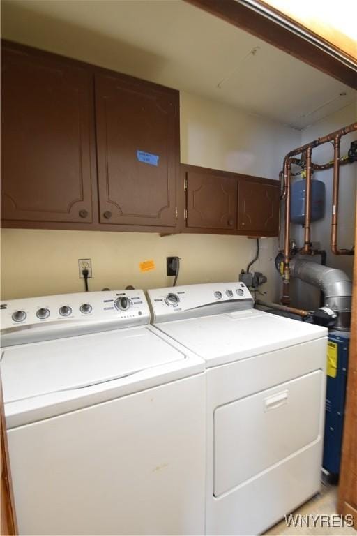 laundry room featuring washing machine and dryer and cabinets