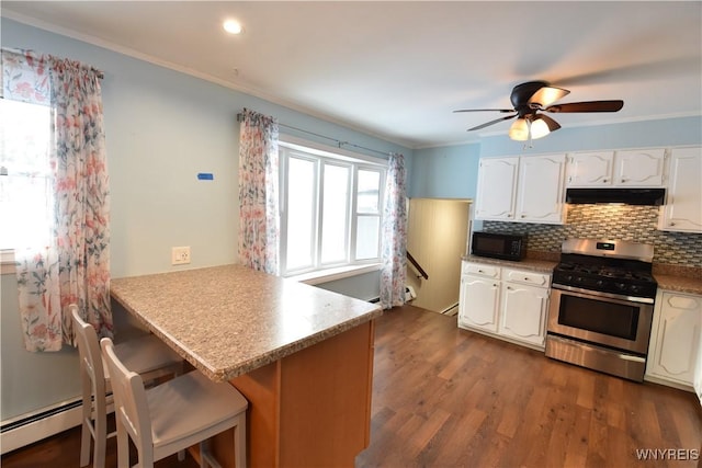 kitchen featuring stainless steel gas range, a breakfast bar, white cabinetry, backsplash, and kitchen peninsula