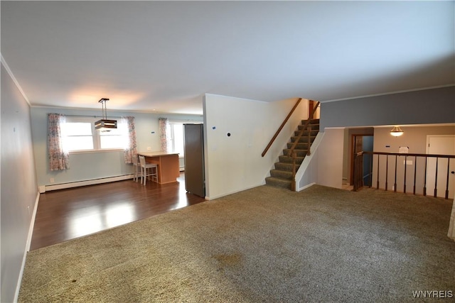 unfurnished living room with baseboard heating, crown molding, and dark colored carpet