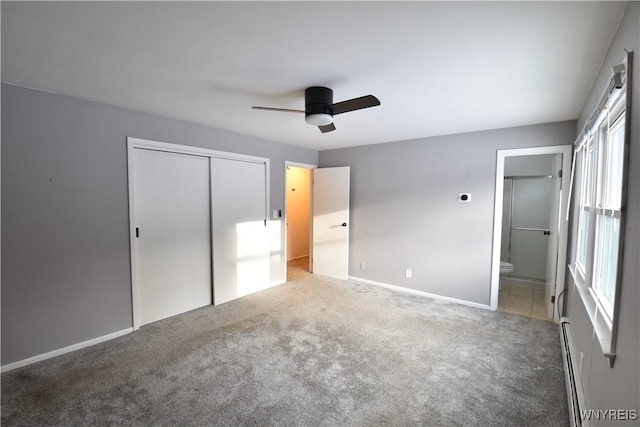 unfurnished bedroom with ceiling fan, a baseboard heating unit, connected bathroom, carpet floors, and a closet