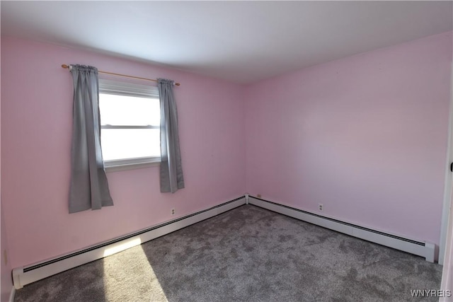 spare room with baseboard heating and carpet