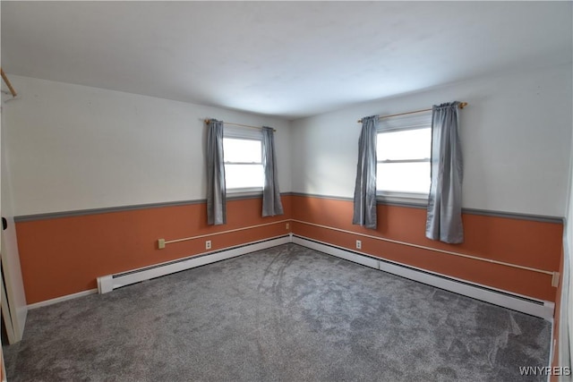 unfurnished room with a baseboard radiator and dark carpet