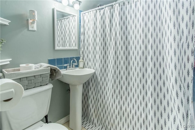 bathroom featuring curtained shower and toilet