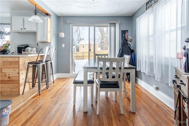 dining room with a textured ceiling and light wood-type flooring