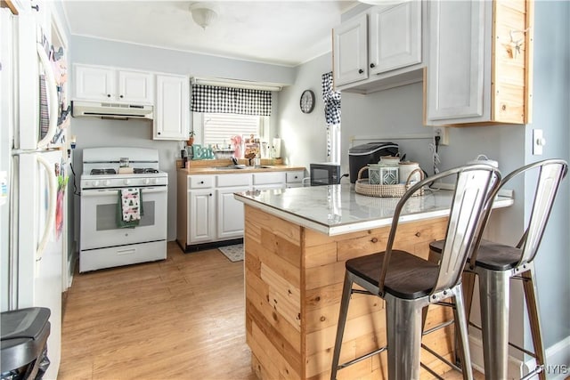 kitchen with sink, white appliances, ornamental molding, white cabinets, and light wood-type flooring