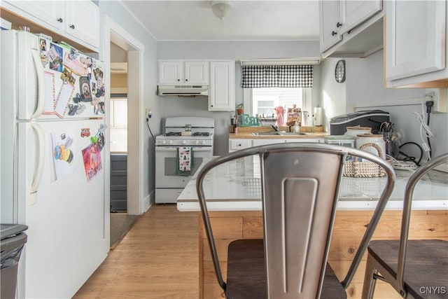 kitchen with white appliances, light hardwood / wood-style floors, and white cabinets