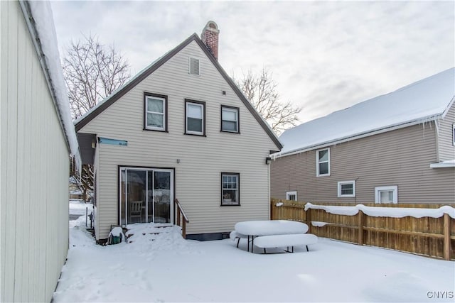 view of snow covered back of property