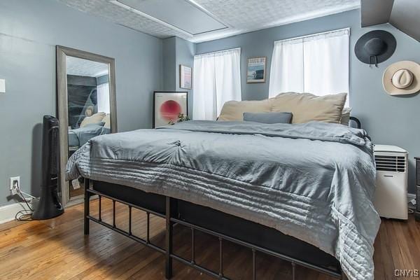 bedroom with hardwood / wood-style floors and a textured ceiling