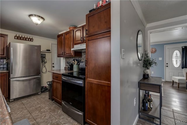 kitchen featuring crown molding, appliances with stainless steel finishes, dark stone countertops, and decorative backsplash