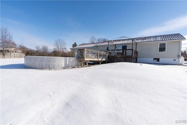 snow covered rear of property with a wooden deck and a gazebo