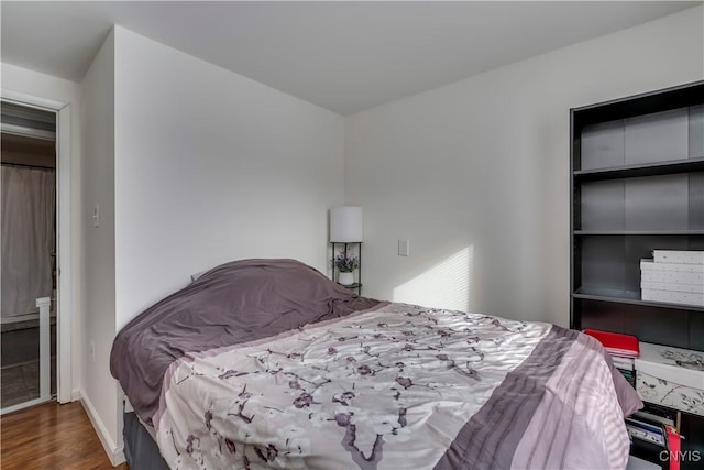 bedroom with dark wood-type flooring