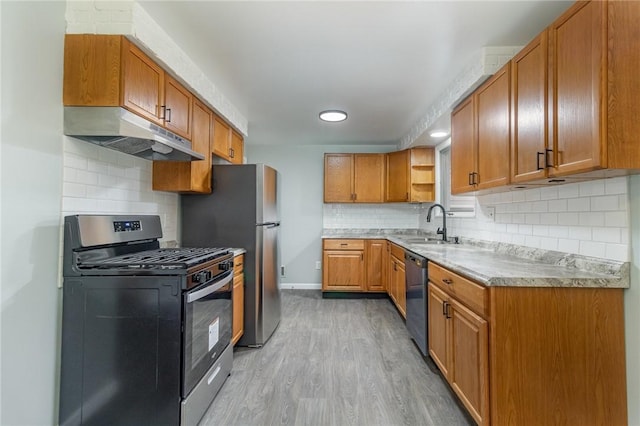 kitchen featuring stainless steel appliances, tasteful backsplash, sink, and light hardwood / wood-style flooring