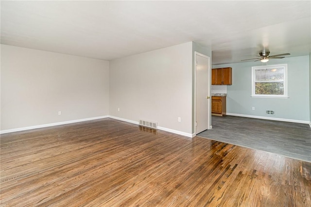 unfurnished living room with dark hardwood / wood-style flooring and ceiling fan